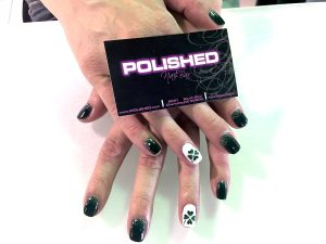 sparkly green manicure with white accent nail that has a shamrock on it